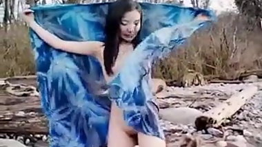 Asian slut is on the beach naked posing